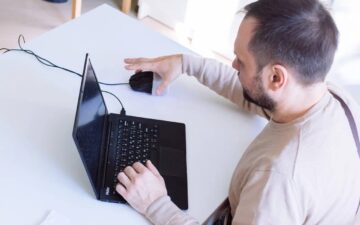 Человек после инсульта сидит за компьютером Человек после инсульта сидит за компьютером